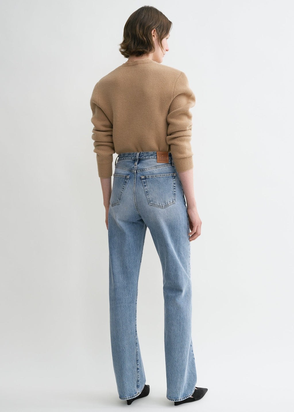https://cdn.shopify.com/s/files/1/0480/1141/1607/files/TOTEME_ECOM_FW24_DENIM_231-240-741_TWISTED_SEAM_DENIM_FULL_LENGTH_WORN_BLUE_044.jpg?v=1723109383