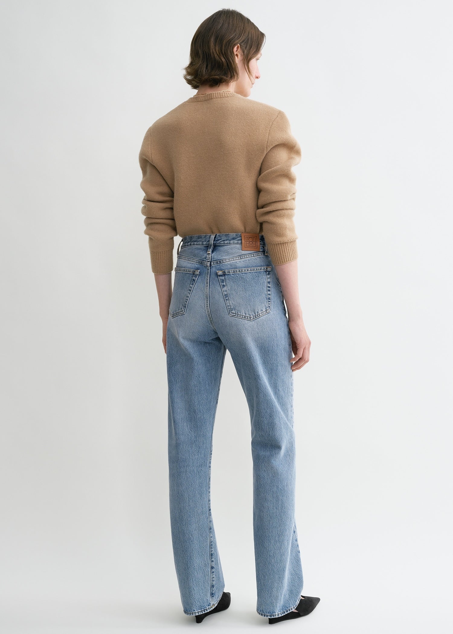 https://cdn.shopify.com/s/files/1/0480/1141/1607/files/TOTEME_ECOM_FW24_DENIM_231-240-741_TWISTED_SEAM_DENIM_FULL_LENGTH_WORN_BLUE_044.jpg?v=1723109383