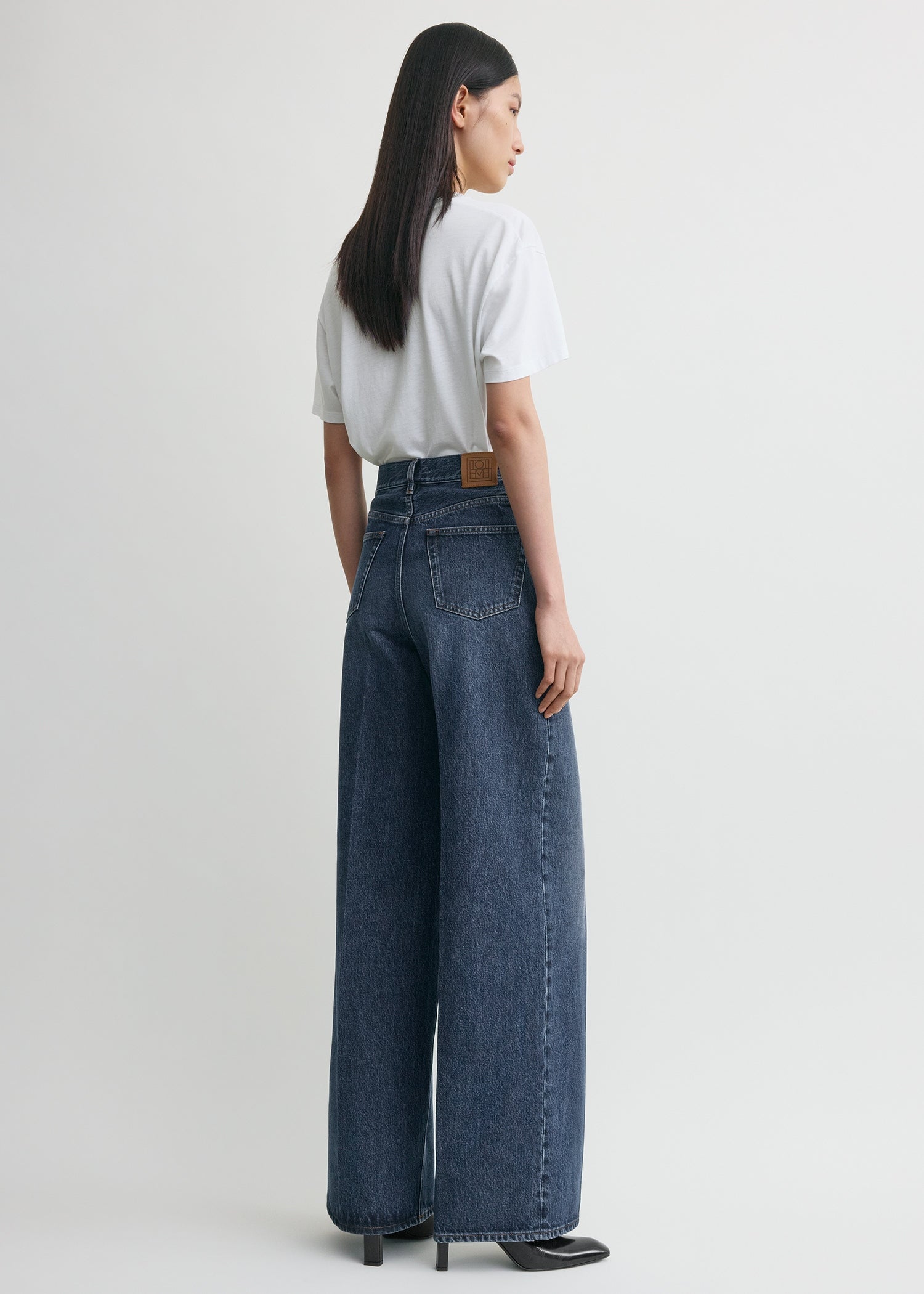 https://cdn.shopify.com/s/files/1/0480/1141/1607/files/TOTEME_ECOM_FW25__JEANS_SEASONAL_242-WRB2426-FB0045_WIDE_LEG_DENIM_DK_BLUE__0052_C.jpg?v=1750935458