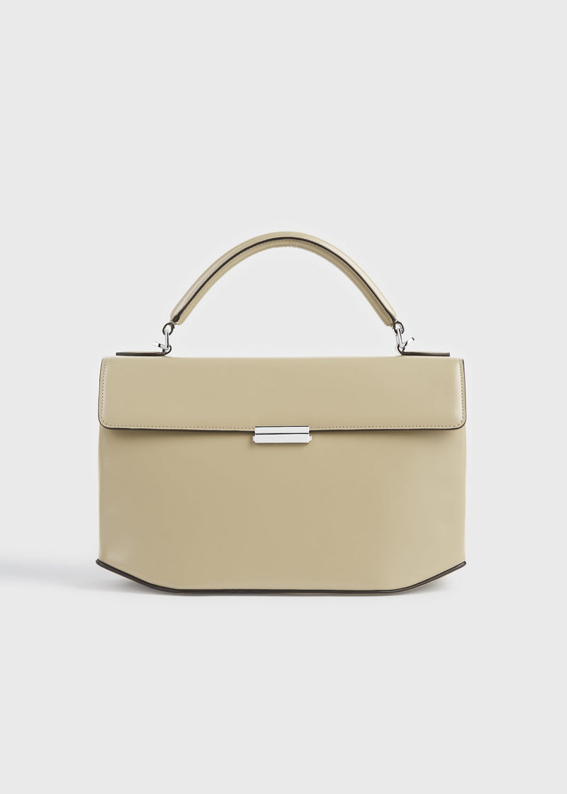 https://cdn.shopify.com/s/files/1/0452/1374/5316/files/TOTEME_FLATS_SS26_SEASONAL_BAGS_262-WAL0125-LE0179-144_CLIP_POLISHED_LEATHER_TOP_HANDLE_CASHEW_front_GB.jpg?v=1768823784