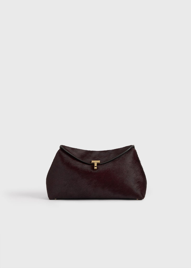 https://cdn.shopify.com/s/files/1/0452/1374/5316/files/TOTEME_FLATS__PS26_SEASONAL_BAGS_251-WAL944-LE0112-346_T-LOCK_PONY_HAIR_CLUTCH_WINE_front_GB.jpg?v=1760599742