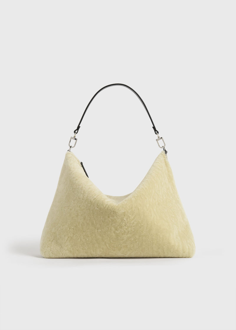https://cdn.shopify.com/s/files/1/0452/1374/5316/files/TOTEME_FLATS__PS26_SEASONAL_BAGS_261-WAL0126-LE0197_MEDIUM_BEVEL_SHEARLING_BAG_BEIGE_front_GB.jpg?v=1760599679